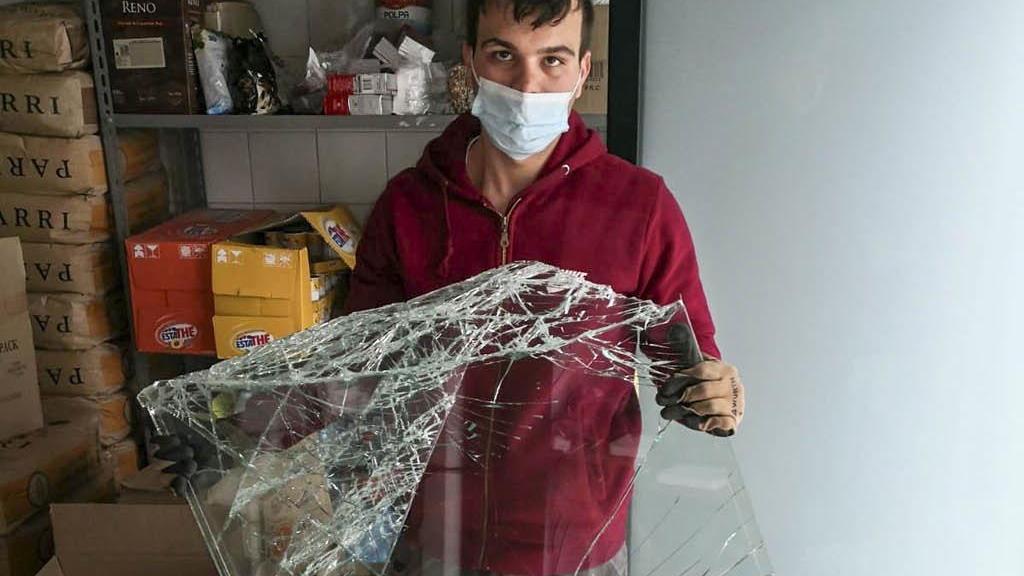 Il titolare con la vetrata spaccata (foto Silvestri)