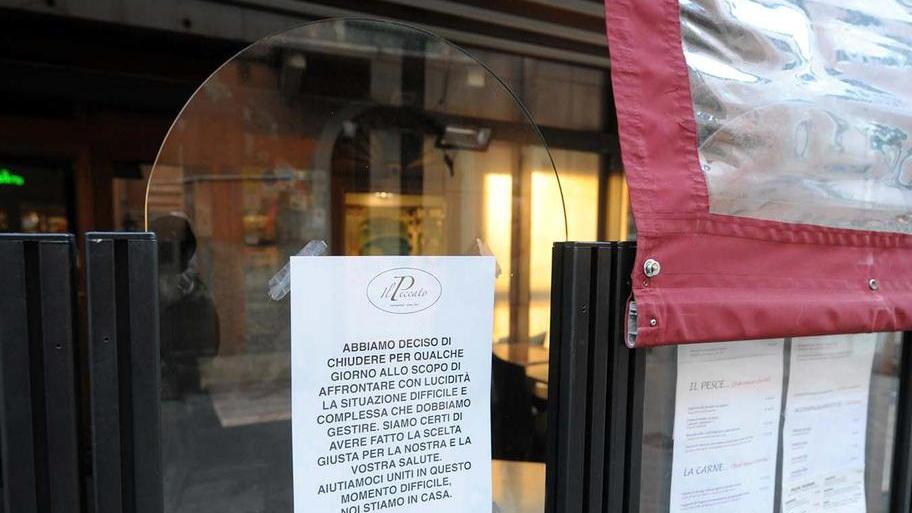 Un cartello sulla vetrina di un locale avvisa della chiusura per le norme anticontagio