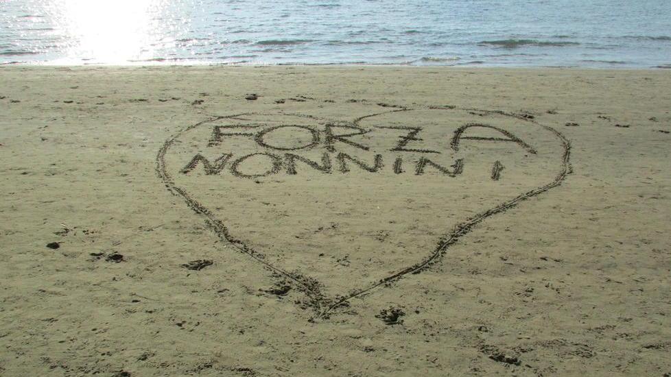 «Forza nonnini»: il significato di quel cuore enorme disegnato sulla sabbia