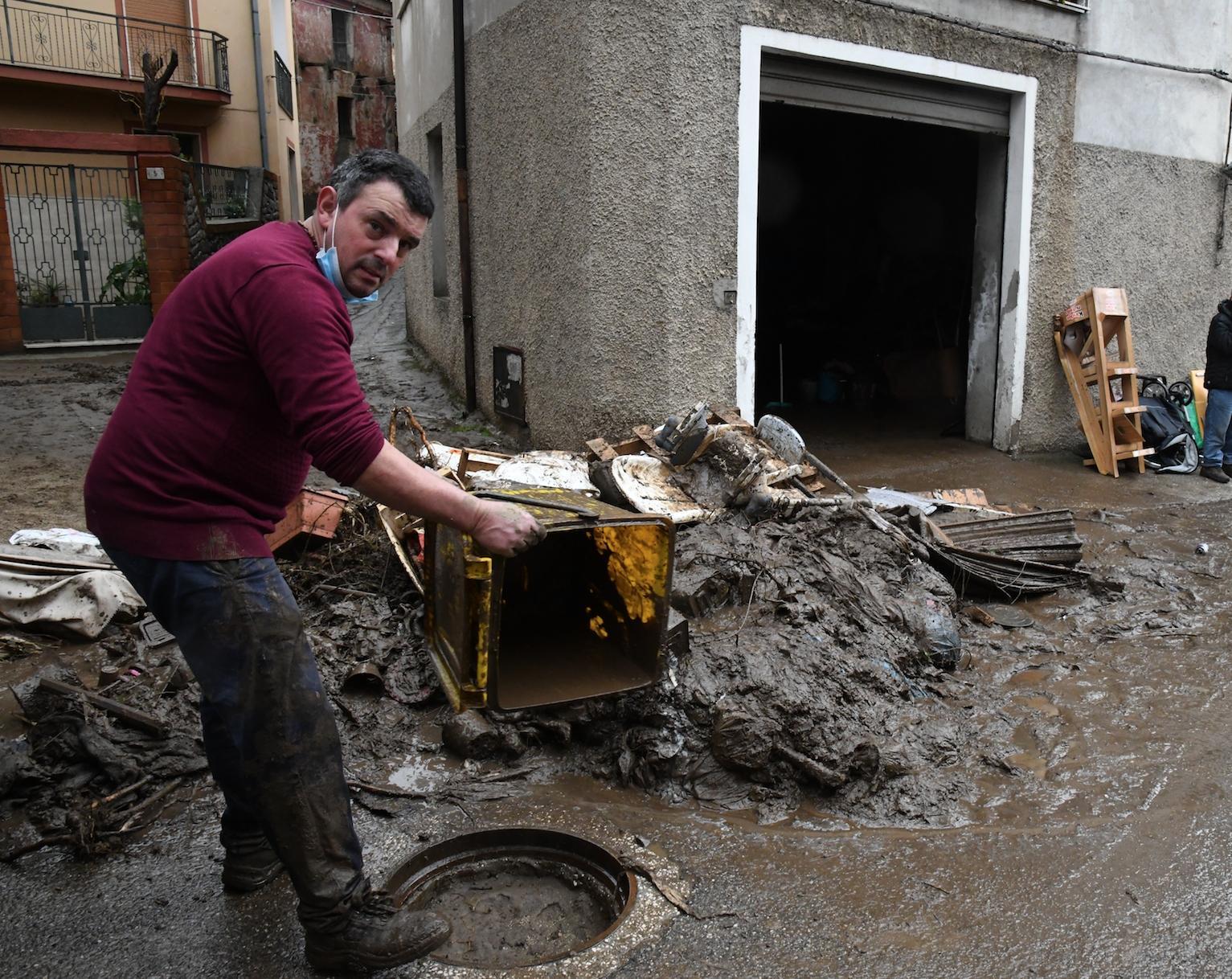 Si cerca di liberare dal fango case e negozi (foto Massimo Locci)