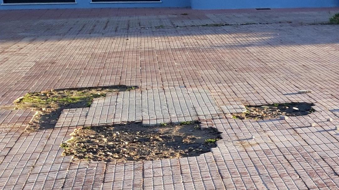 Un marciapiede costellato di buche
