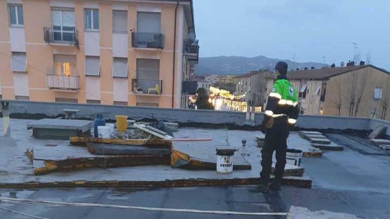 Un volontario Anpana su un capannone dove è stato rimosso un telone