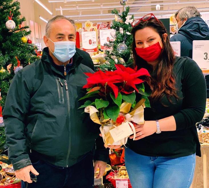 Gino Roberto, consegna una stella di Natale alla caponegozio Vanessa Betta, per ringraziarla