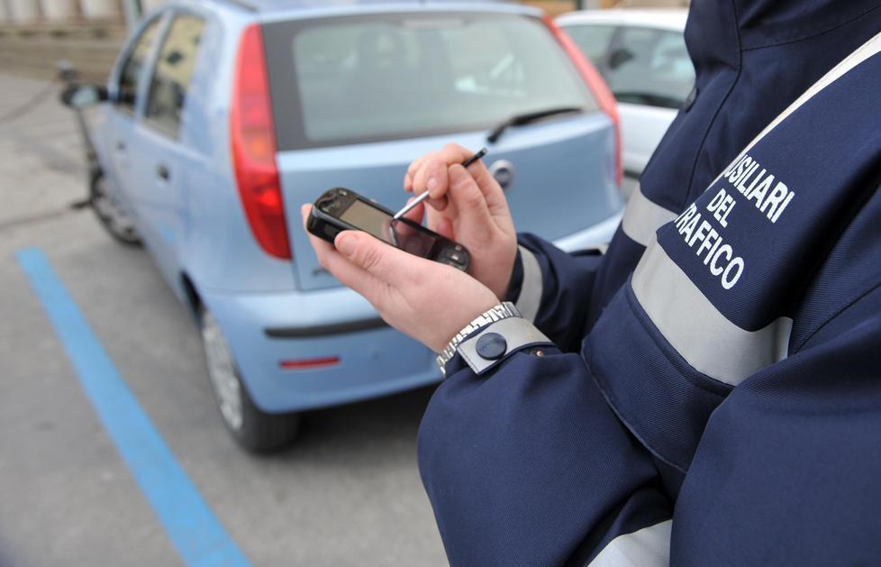 Un ausiliario del traffico verifica la regolarità di un’auto
