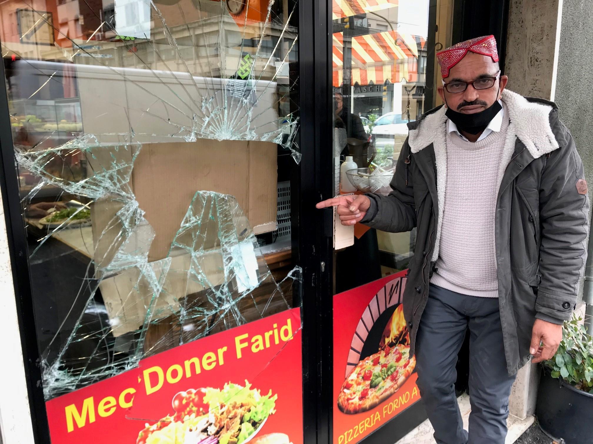 Farid mostra la vetrina del suo ristorante spaccata dai malvivente