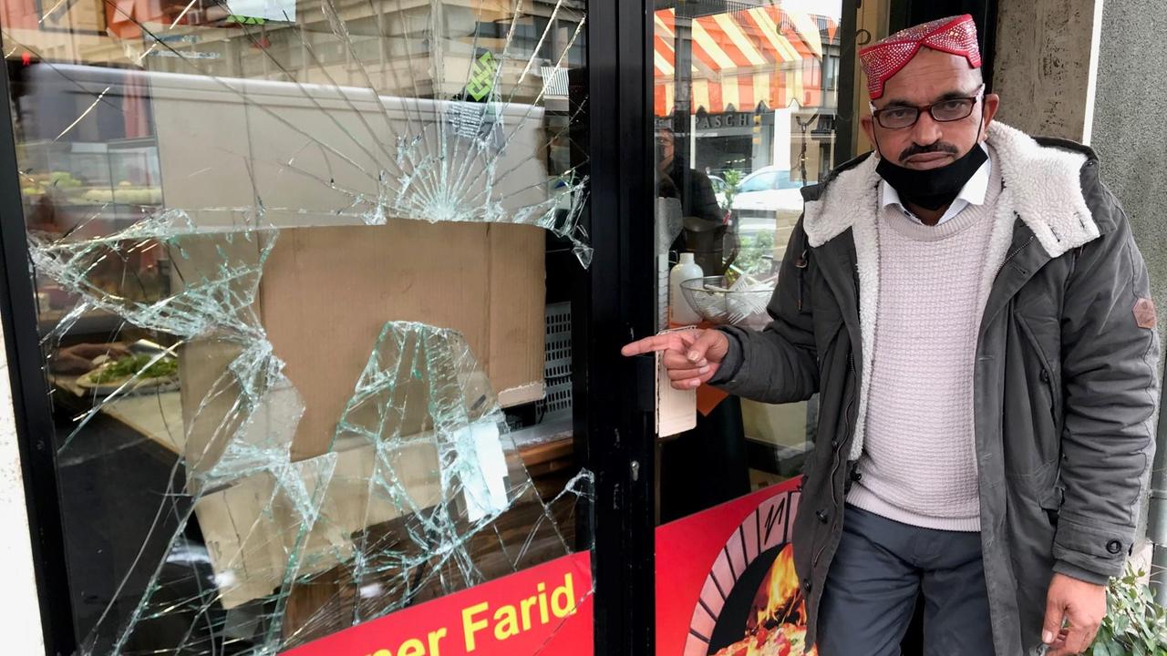 Farid mostra la vetrina del suo ristorante spaccata dai malvivente