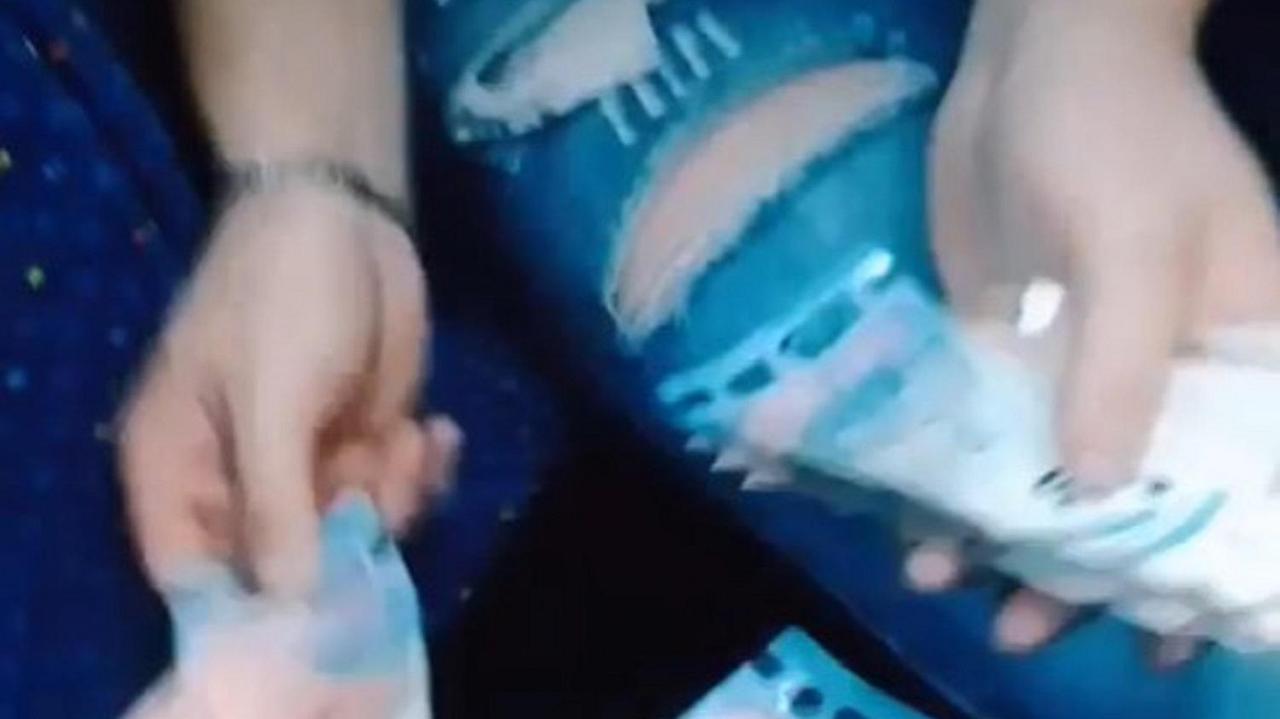 Un fotogramma del video in cui uno dei rapinatori mostra i soldi