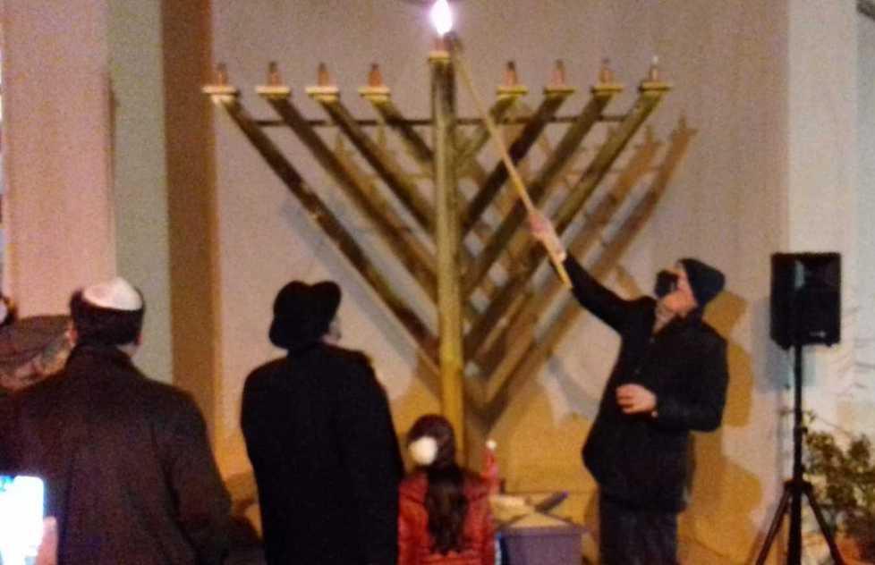 Il sindaco Luca Salvetti mentre accende il candelabro ebraico