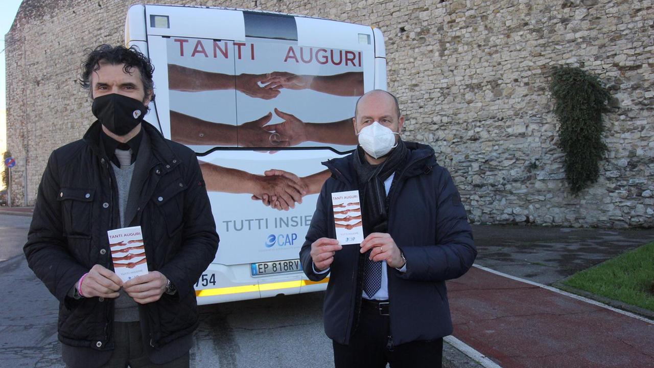 Il sindaco Matteo Biffoni insieme al presidente della Cap Federico Toscano davanti al cartellone di auguri sull'autobus