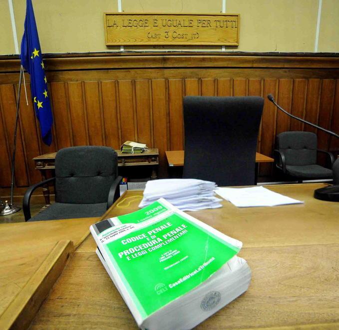 Un'aula di tribunale e un Codice penale e di Procedura penale