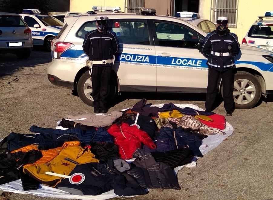 Borsoni in spiaggia pieni di vestiario con griffe contraffatte