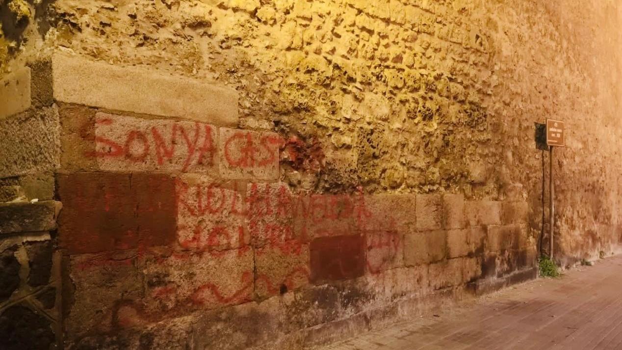 Le mura medievali della città imbrattate con una scritta rossa