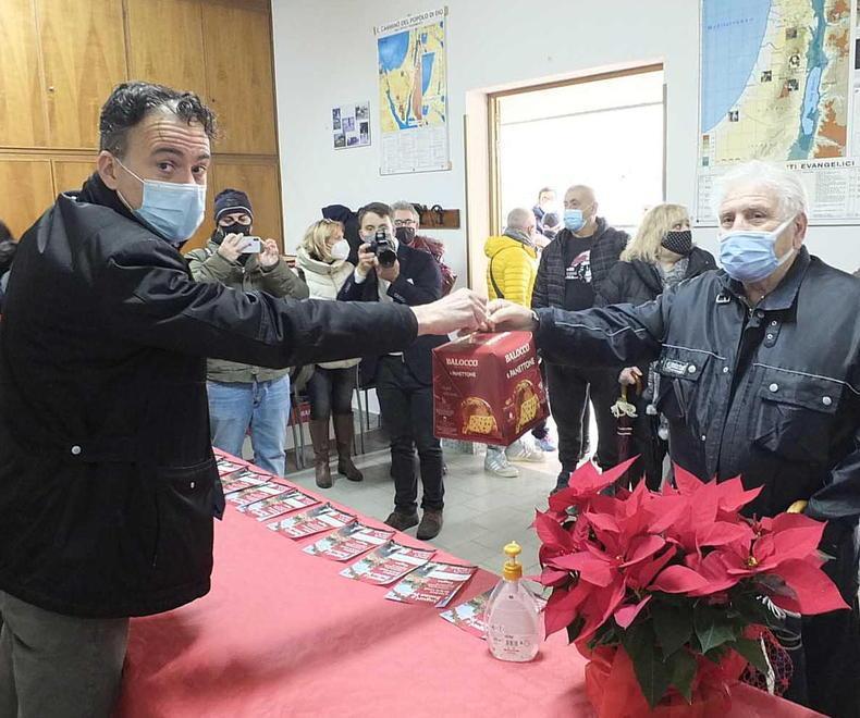Il sindaco Michele Conti mentre consegna un panettone a un residente di Gagno (foto Muzzi)