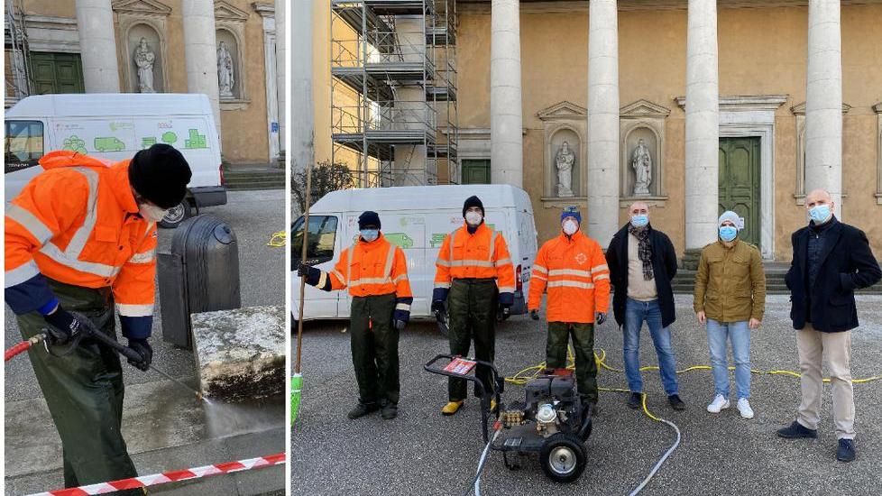 Un addetto alle pulizie dell’arredo urbano mentre usa l’idropulitrice e la foto di gruppo per la consegna del dispositivo al Comune (foto f. silvi)