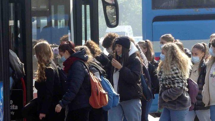 studenti mentre salgono su un bus di linea diretti a scuola