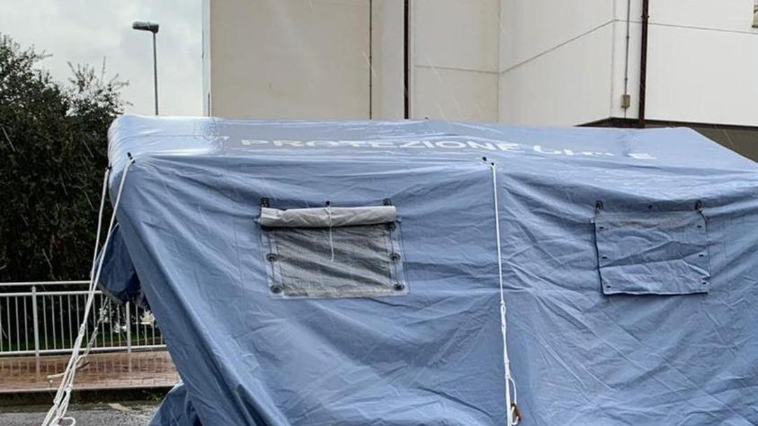 Il vento butta giù la tenda per la vestizione anti covid