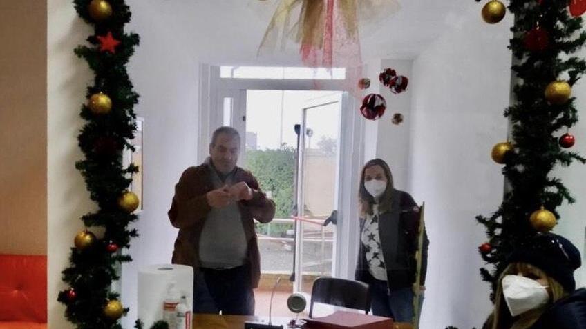 In primo piano sulla destra la signora Viola e, oltre la barriera di plexiglas, Luigi con una operatrice della residenza sanitaria
