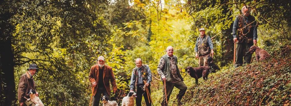 I tartufai diventano modelli insieme ai loro cani nel bosco per la candidatura all’Unesco 