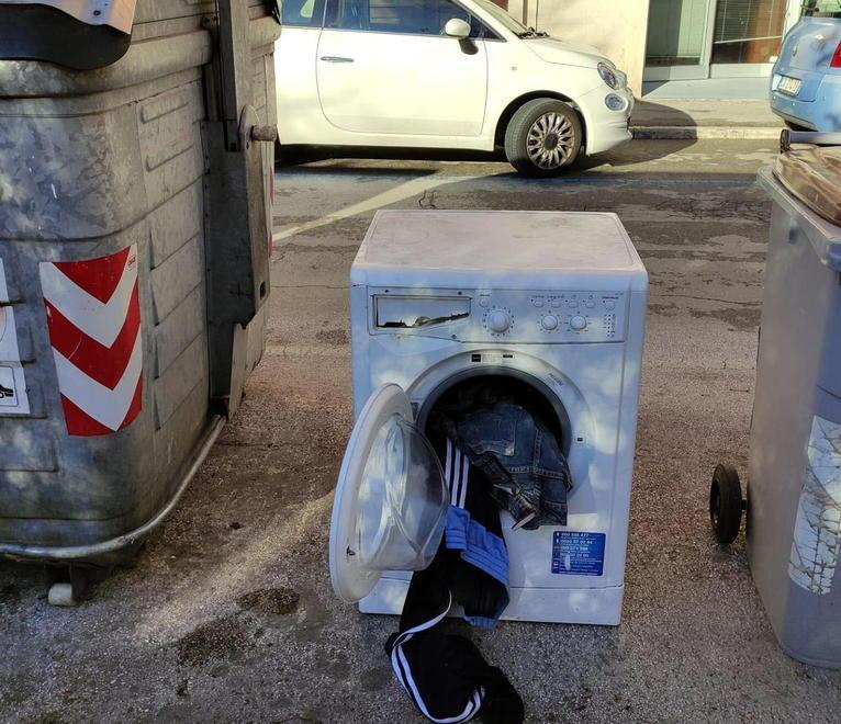 Lavatrice coi panni che escono dal cestello