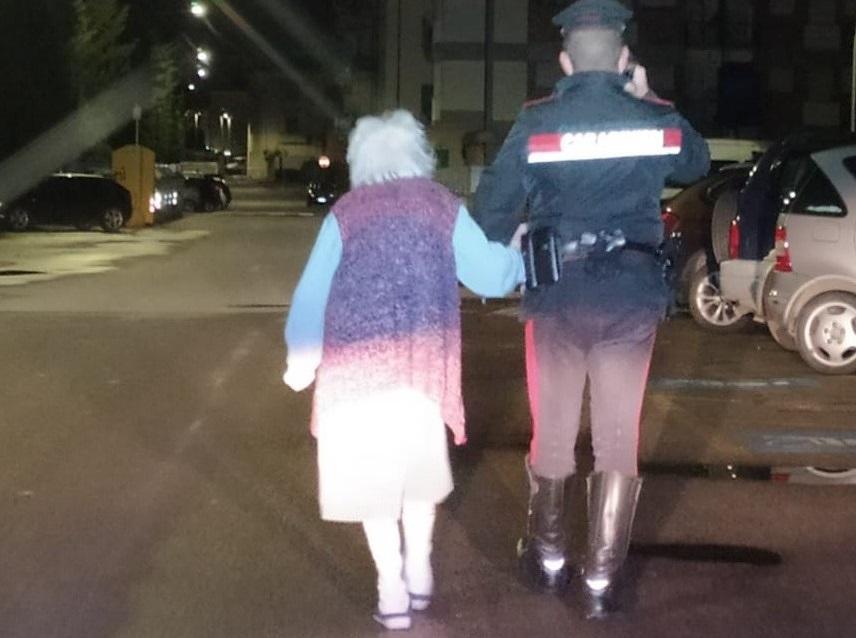L'anziana sotto braccio a uno dei carabinieri che l'hanno rintracciata e riportata a casa nel cuore della notte