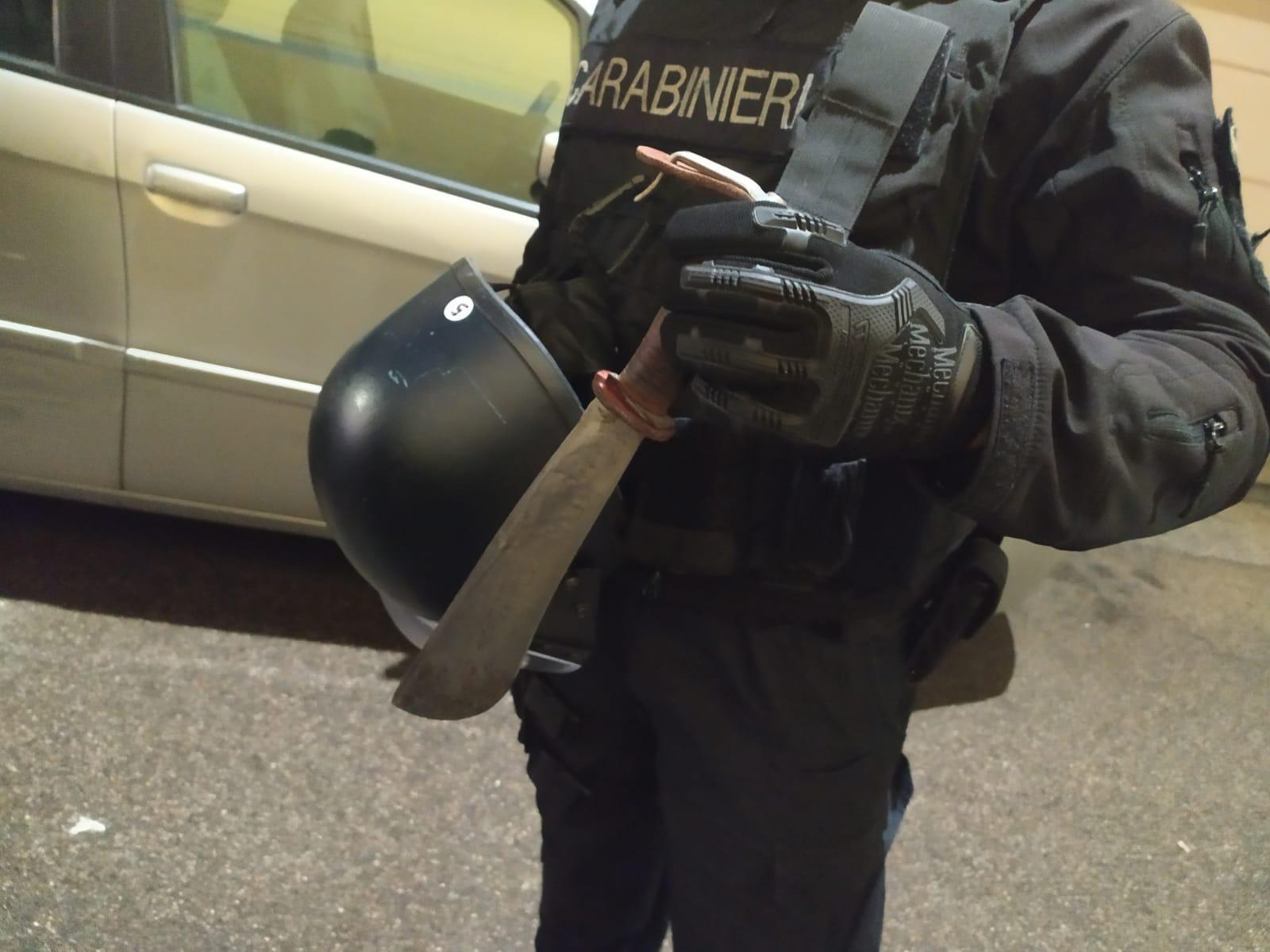 Un carabiniere mostra la roncola utilizzata dal 67enne per minacciare i vicini
