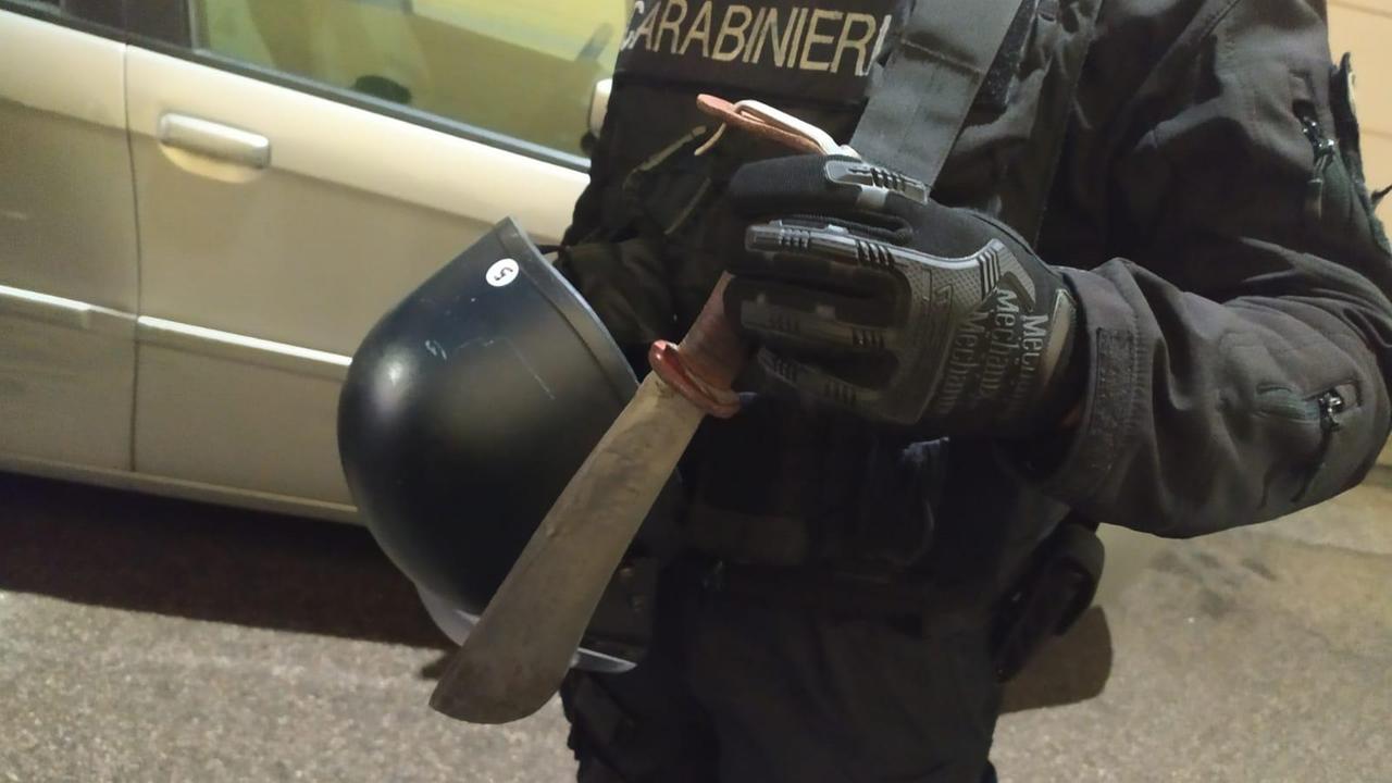Un carabiniere mostra la roncola utilizzata dal 67enne per minacciare i vicini