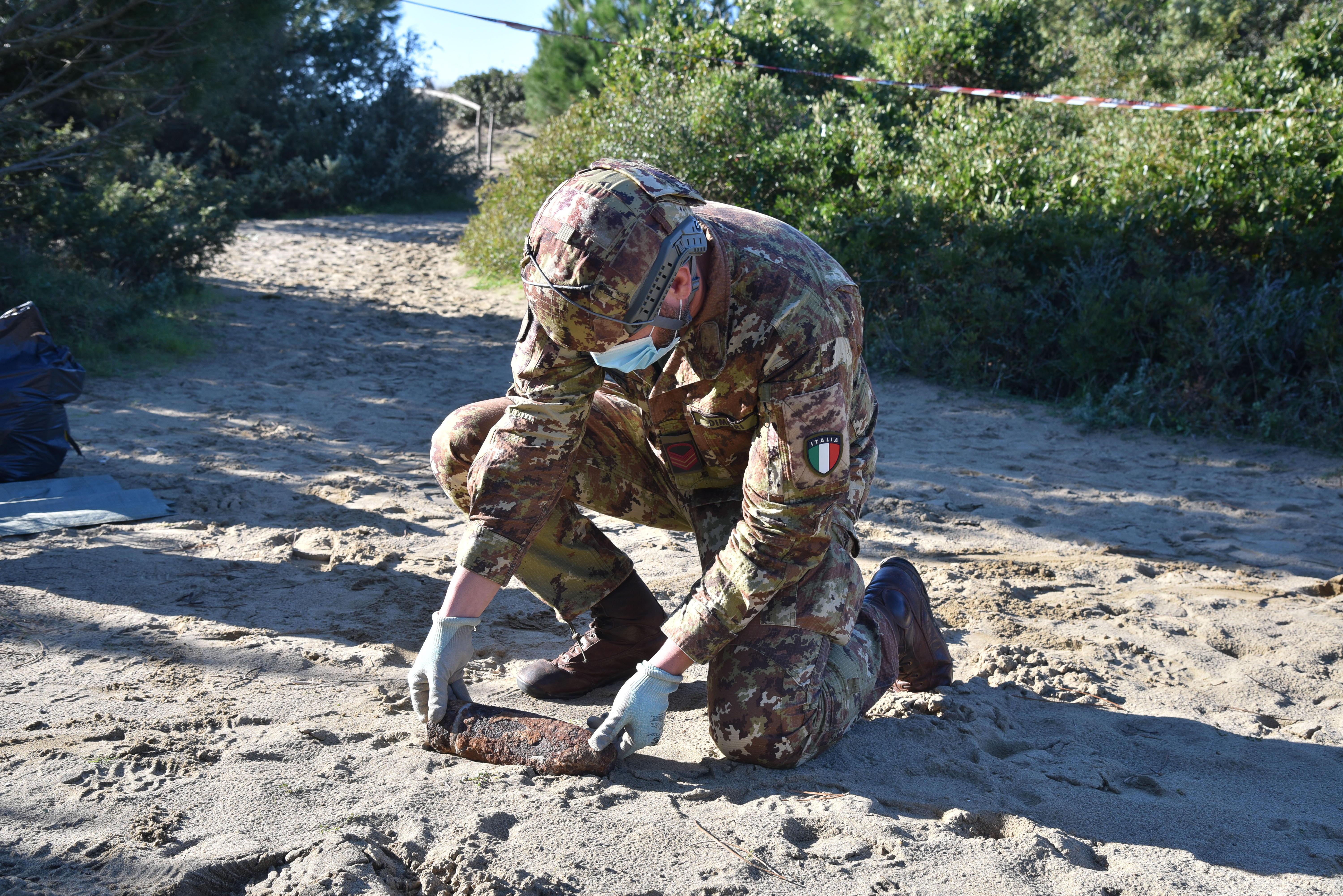 Il caporalmaggiore capo scelto dell'esercito, Giuseppe Dimitri, del 2° Reggimento Pontieri di Piacenza, preleva dalla sabbia l'ordigno bellico (foto Agenzia Bf)