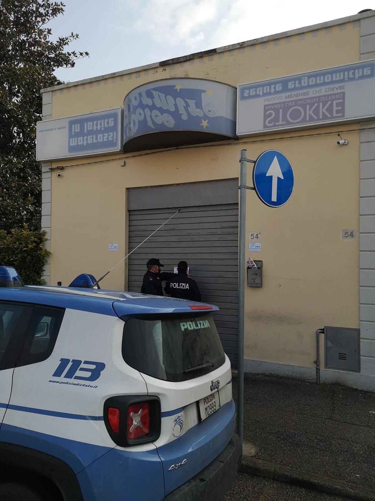 La polizia mentre appone l'ordine di chiusura al market
