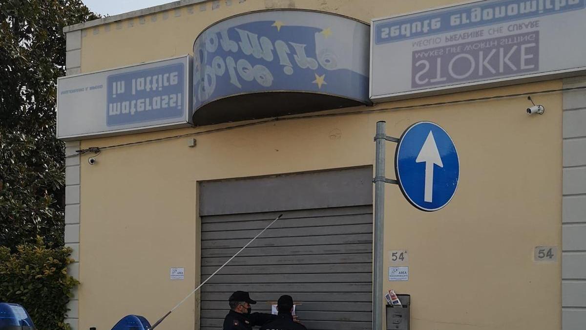 La polizia mentre appone l'ordine di chiusura al market