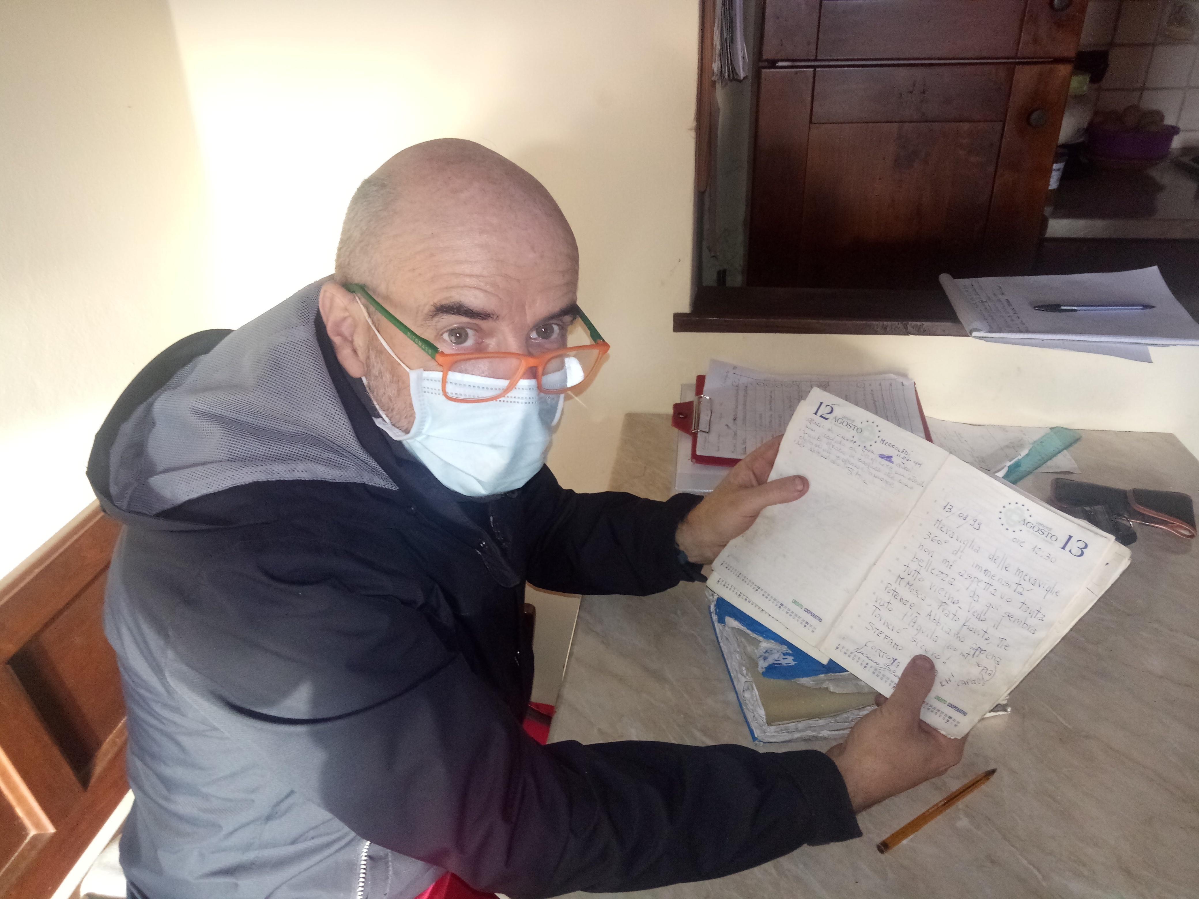Lo scrittore Federico Pagliai mostra uno dei libri di vetta di cui si occupa da più di 30 anni