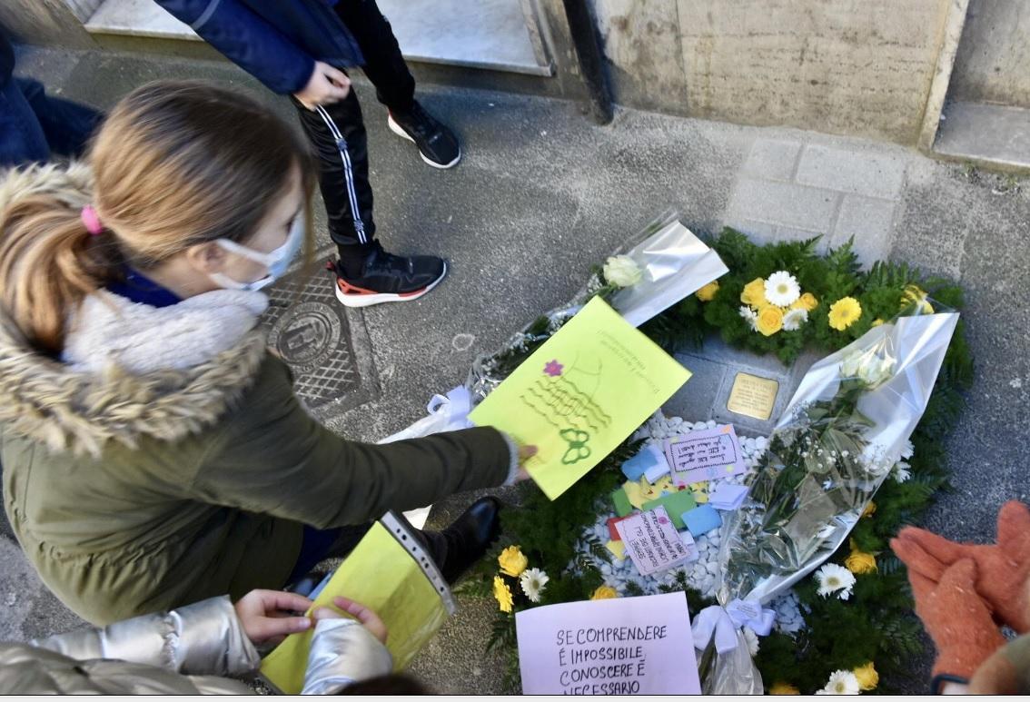 La deposizione di fiori accanto alla "pietra d'inciampo" dedicata a Gigliola Fiunzi, uccisa a sei mesi a Auschwitz