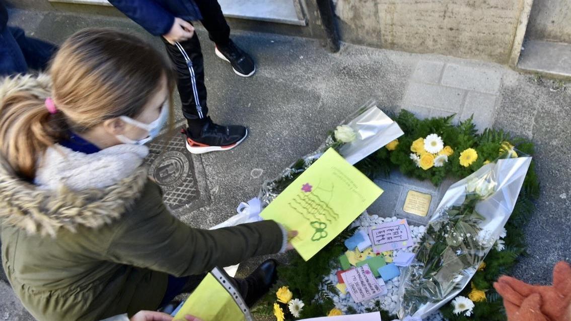 La deposizione di fiori accanto alla "pietra d'inciampo" dedicata a Gigliola Fiunzi, uccisa a sei mesi a Auschwitz