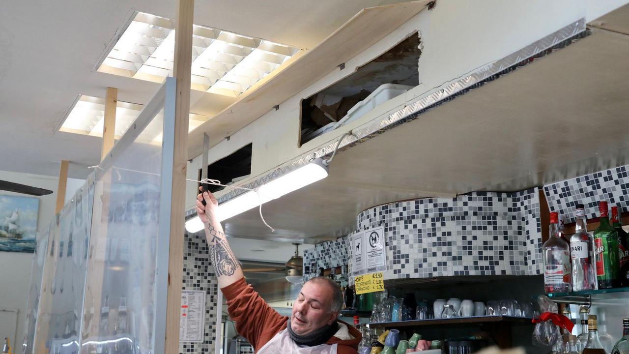 Il gestore del bar ristorante Il Delfino indica il punto dove è crollato il controsoffitto
