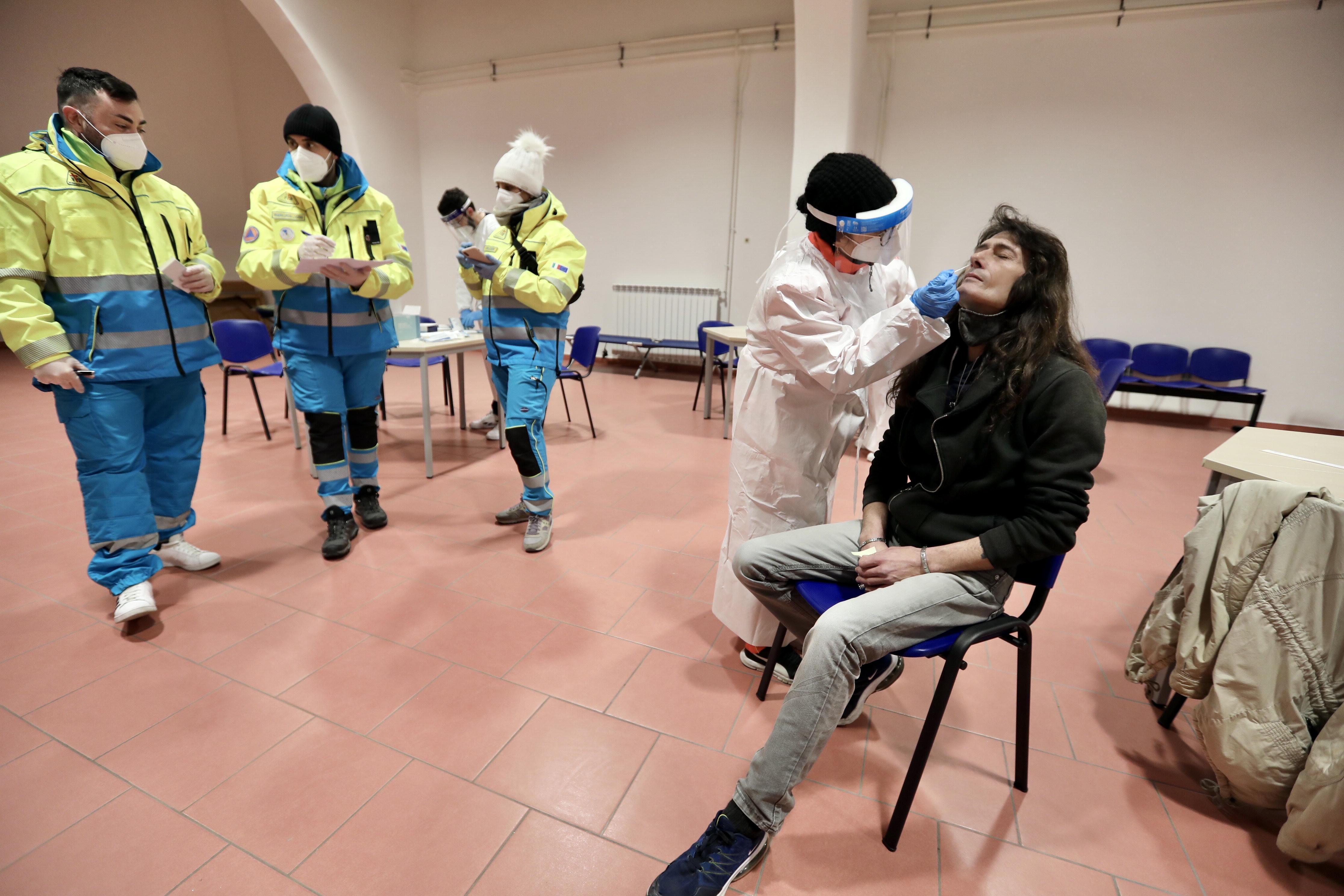 Claudio De Giulli, 50 anni, mentre viene sottoposto al tampone dai volontari