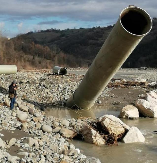 I giganteschi tubi affiorano dall’acqua del torrente Dolo o sono in stato di disfacimento e abbandono sul greto del corso d’acqua
