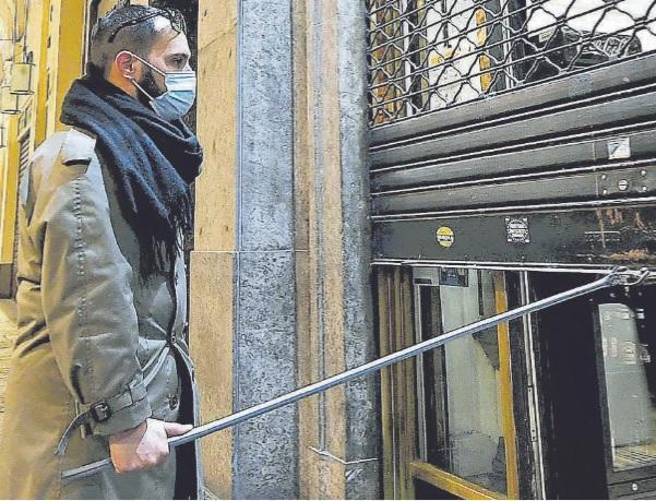 Un esercente abbassa la saracinesca della sua attività (Foto d’archivio)