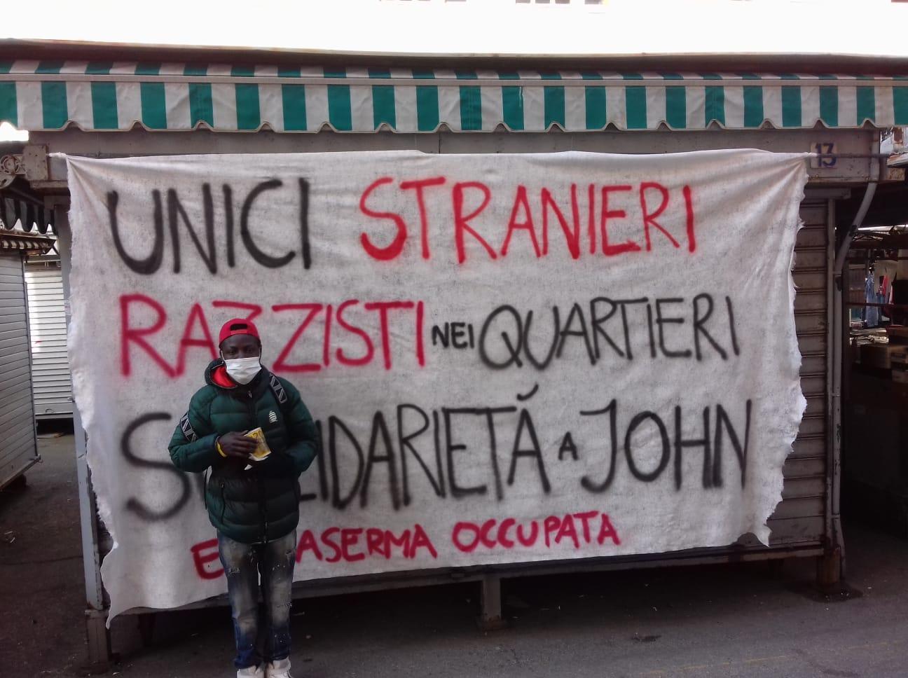 John Samoslo davanti al cartello dell'Ex caserma occupata