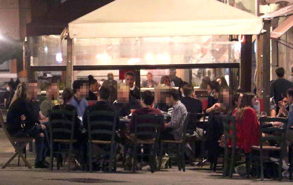 Un gruppo di giovani seduti davanti a un locale