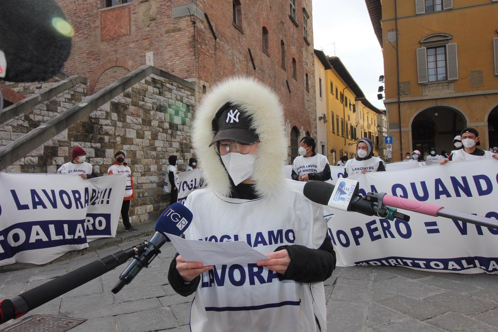 Una dipendente della Texprint legge un volantino alla manifestazione contro lo sciopero in piazza del Comune