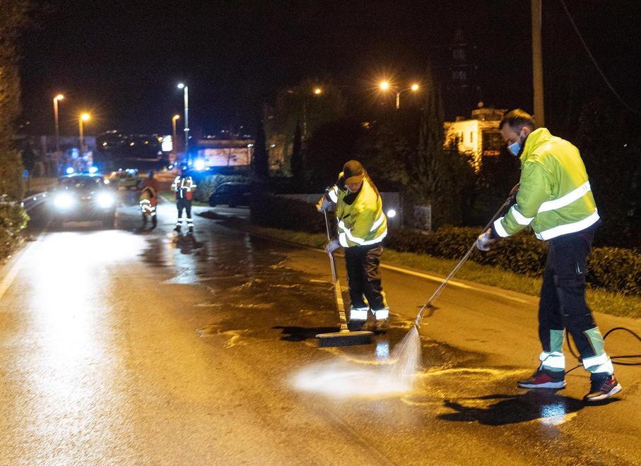 Nella foto due volontari della Protezione civile di Chiesina Uzzanese impegnati a lavare la strada dalla lunga scia di gasolio persa dal camion  (Fotoservizio Innocenti/Nucci)