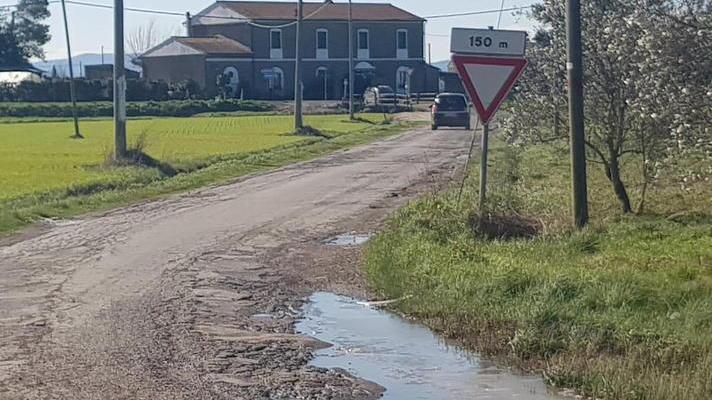 Strada dissestata da anni e sacchi di rifiuti abbandonati