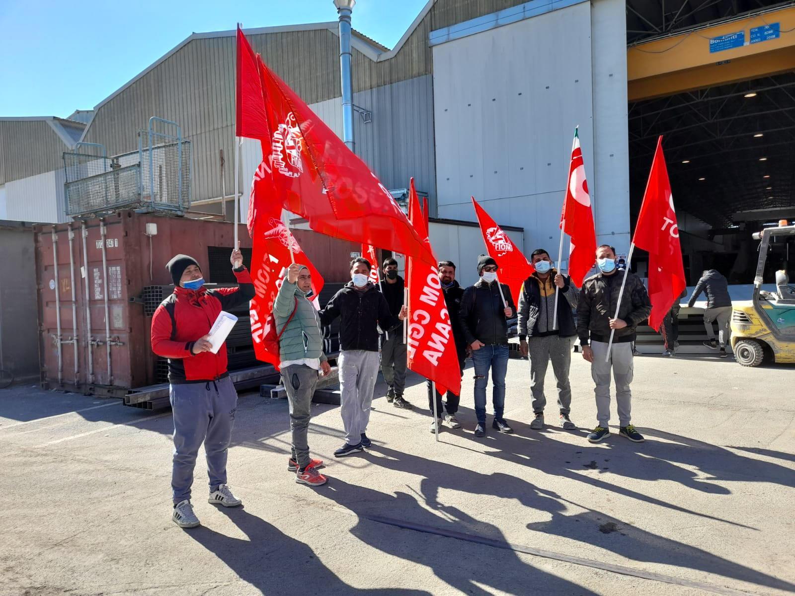 Gli (ex) operai della MsMc quando ancora erano all’interno della ditta sub-appaltatrice dei lavori agli scafi di imbarcazioni di trenta metri: sventolano le bandiere del sindacato che da qualche tempo li tutela