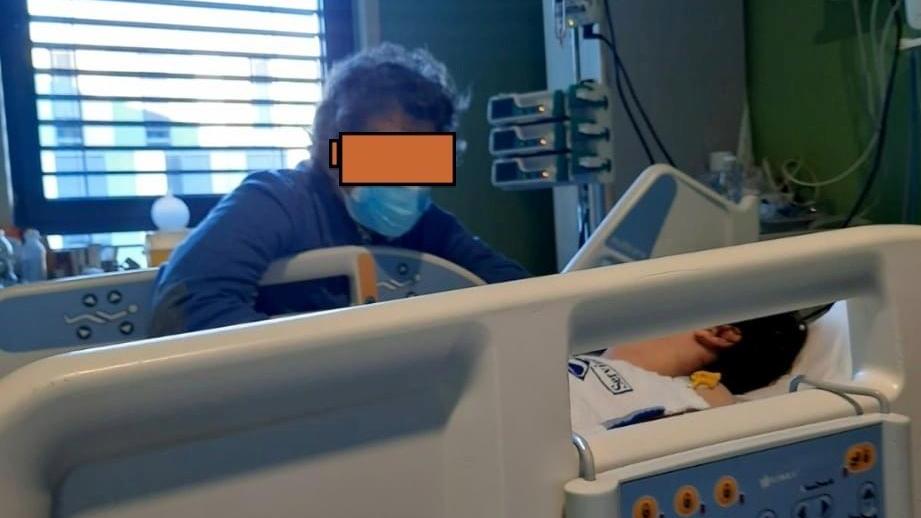 Il padre assiste suo figlio in rianimazione