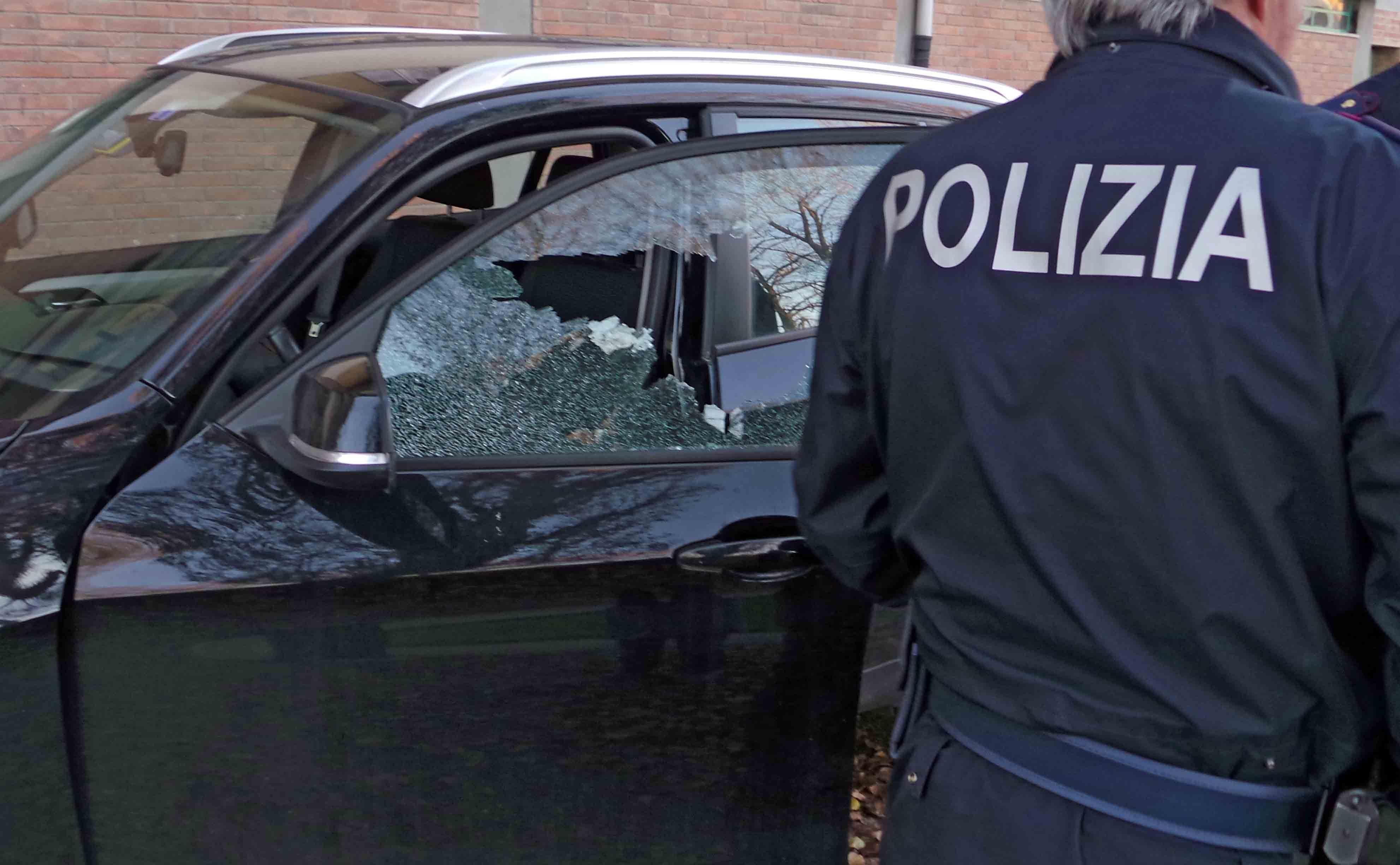 Un finestrino rotto e un agente della polizia (foto d'archivio)