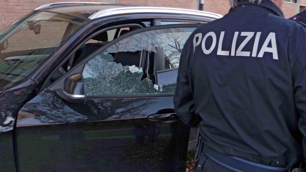 Un finestrino rotto e un agente della polizia (foto d'archivio)