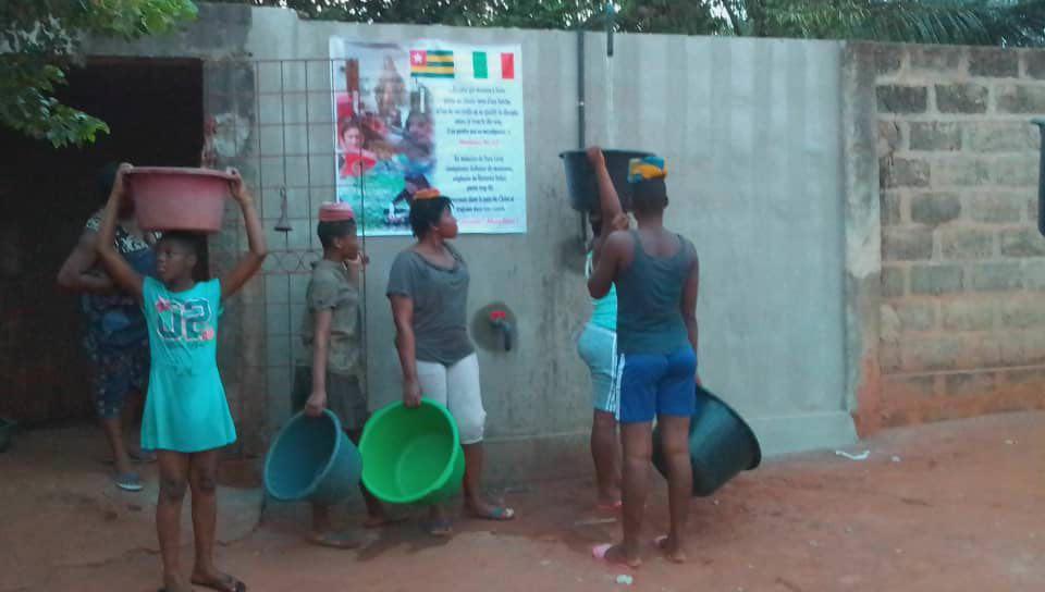 Nella foto grande ragazzi in fila al primo pozzo in Togo inaugurato già nel gennaio scorso grazie all’associazione “Sara Lenzi pilota"
