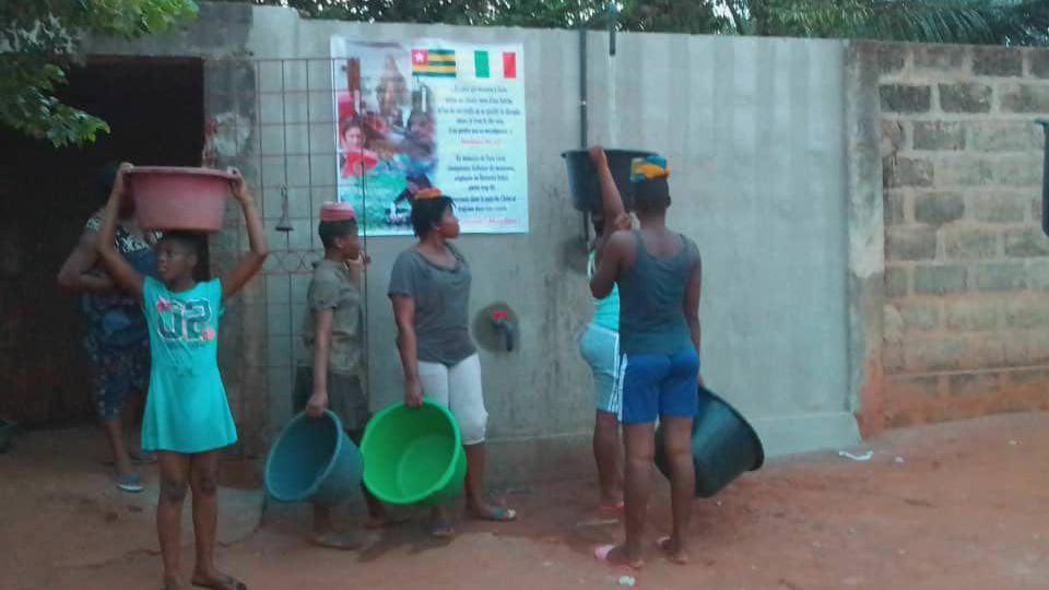 Nella foto grande ragazzi in fila al primo pozzo in Togo inaugurato già nel gennaio scorso grazie all’associazione “Sara Lenzi pilota"