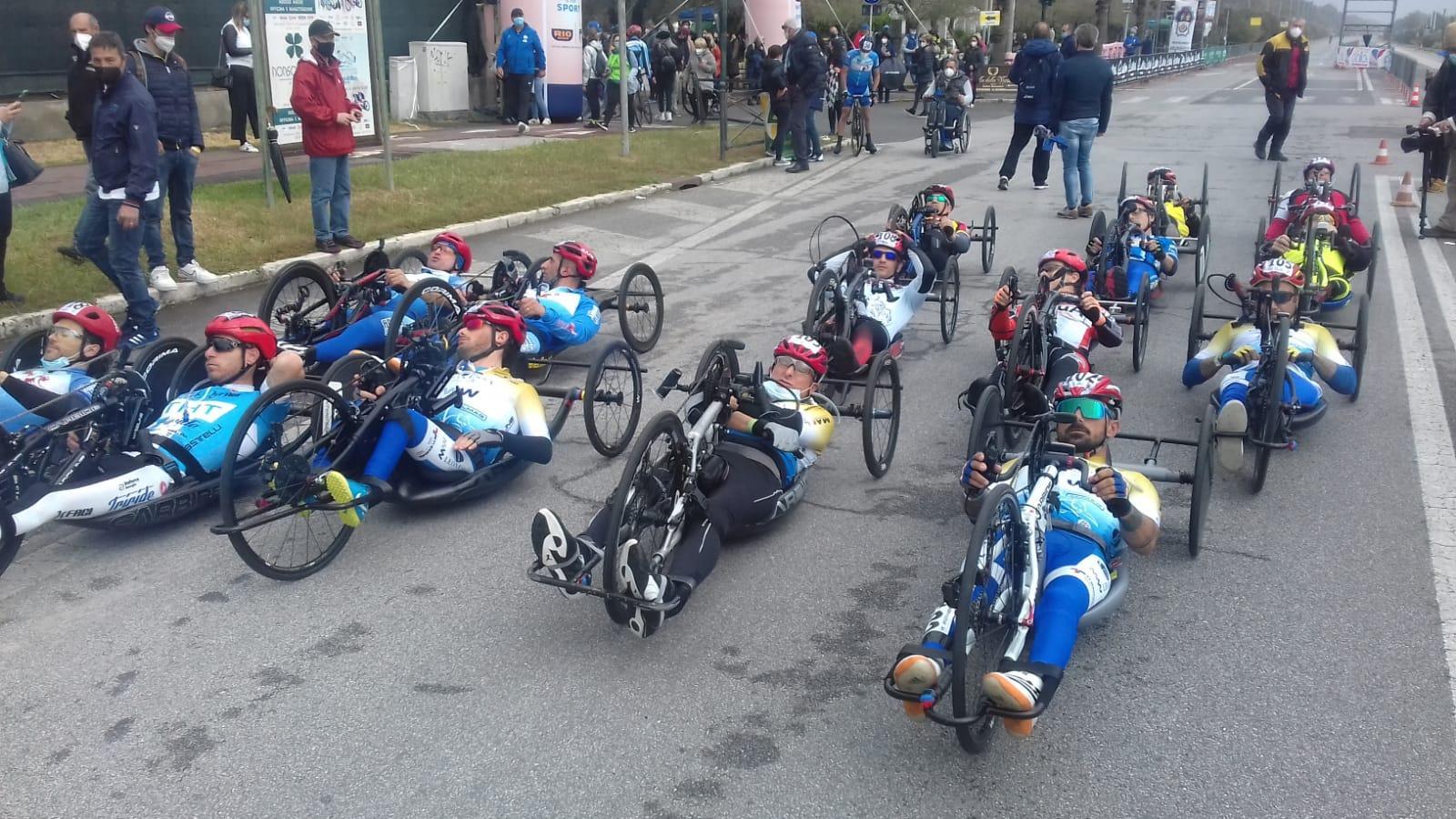 Un gruppo di handbiker in gara sul lungomare di Marina di Massa