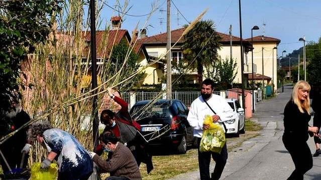 Cittadini al lavoro per pulire il campo