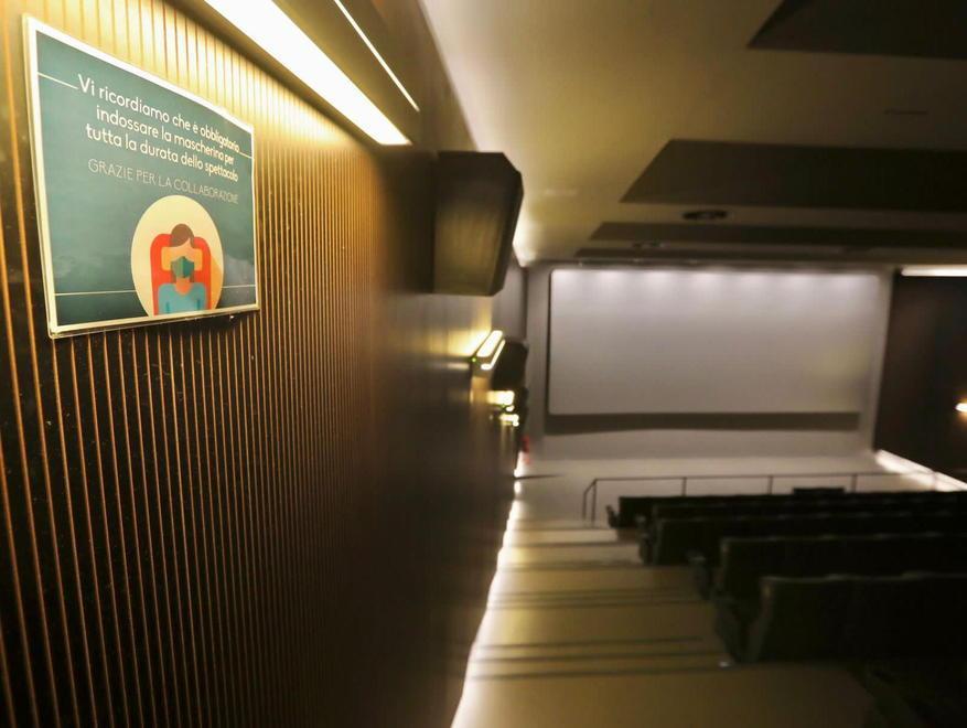 Una sala del cinema con il pannello che ricorda di indossare la masherina (fotoservizio Marzi)